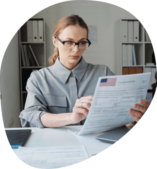 A translator checks passport and USCIS forms at a desk, showing Alexandria Translation Services for USCIS certified filings.