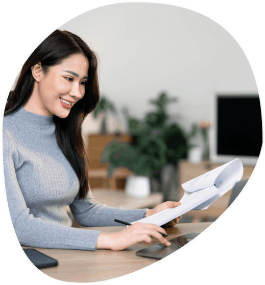 A linguist checks a birth certificate translation at a desk, preparing it for filing with Augusta Translation Services.