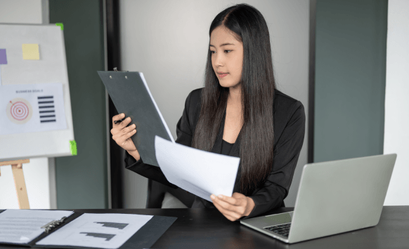 A native translator hands a stamped certified translation to a client in an office, reflecting Translation Services.