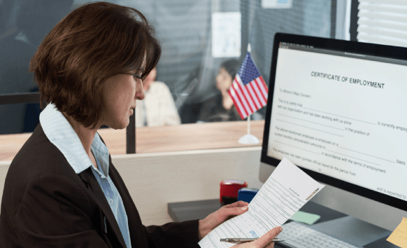 An accredited translator hands a printed USCIS-certified translation to a client in an office, from Translation Services.