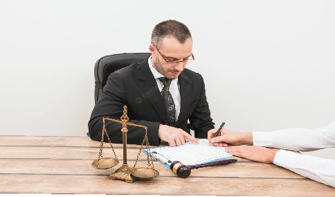 A lawyer checking a legal document, with a gavel and balance beside him 