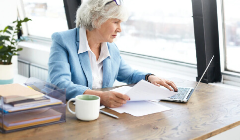 A professional elderly legal translator working on her computer