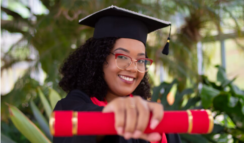 A student holding her graduation degree